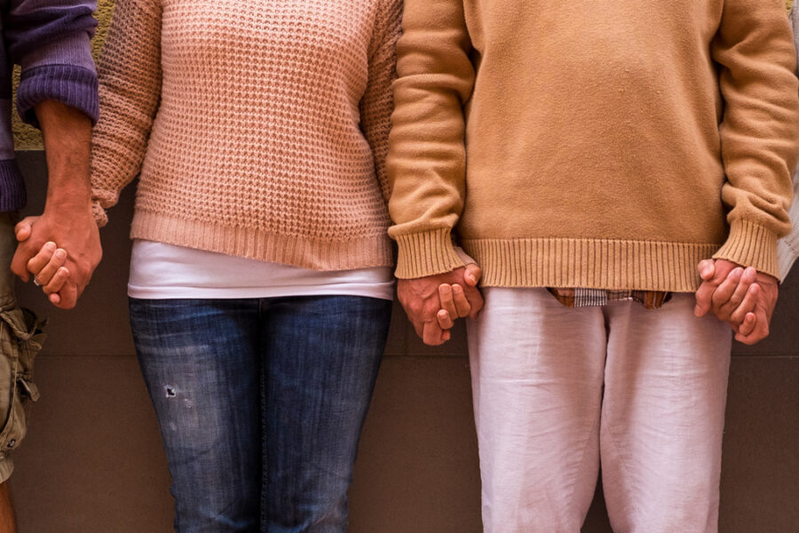 four people together holding their hands together