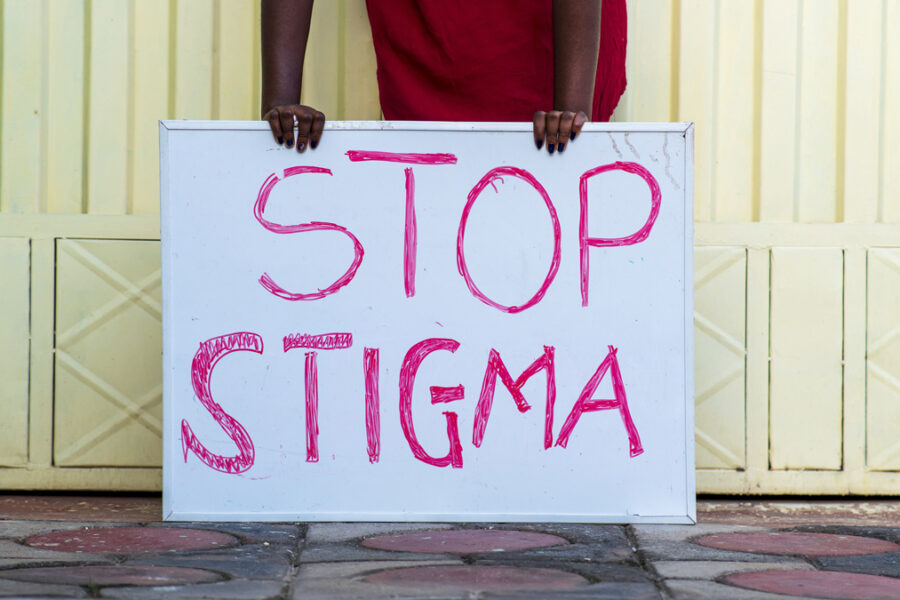 Person holding a sign with text "Stop Stigma"