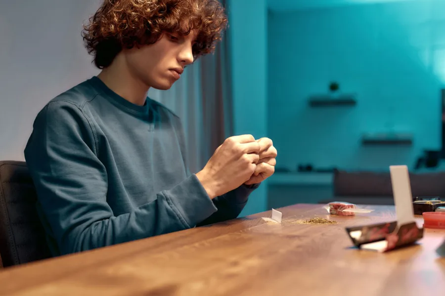 teenager rolling marijuana